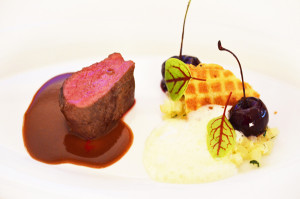 Rehmedaillon mit Waffeln und heißen Kirschen
